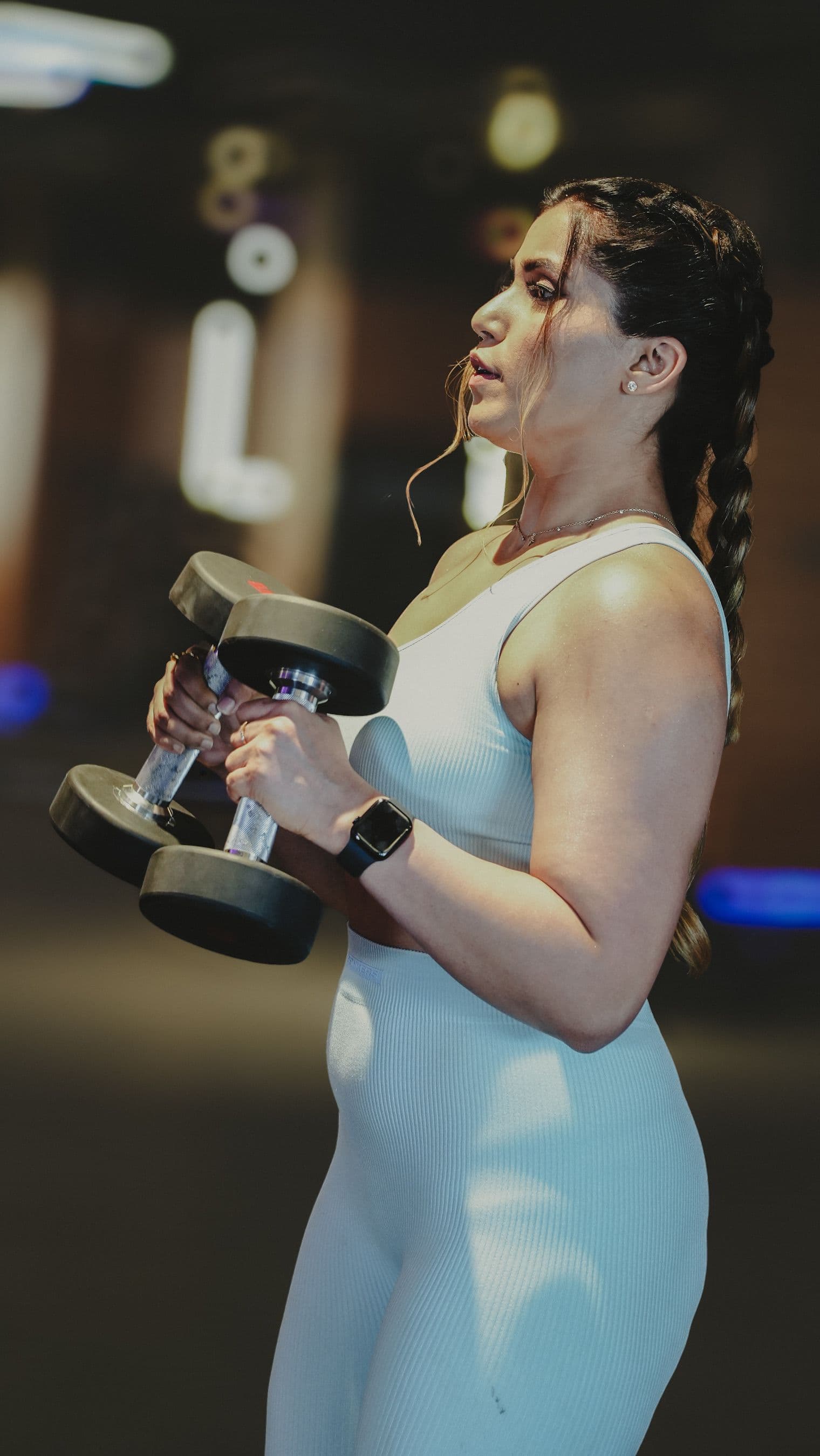 Athlete curling dumbbells with full concentration